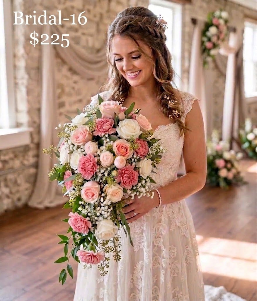 Bridal 16 — This is a lush, cascading bridal bouquet featuring a romantic blend of flowers. It is composed of soft white and light pink roses and pink carnations, and abundant delicate white baby's breath. The arrangement is accented with mixed green foliage, with longer trails creating the signature flowing shape.